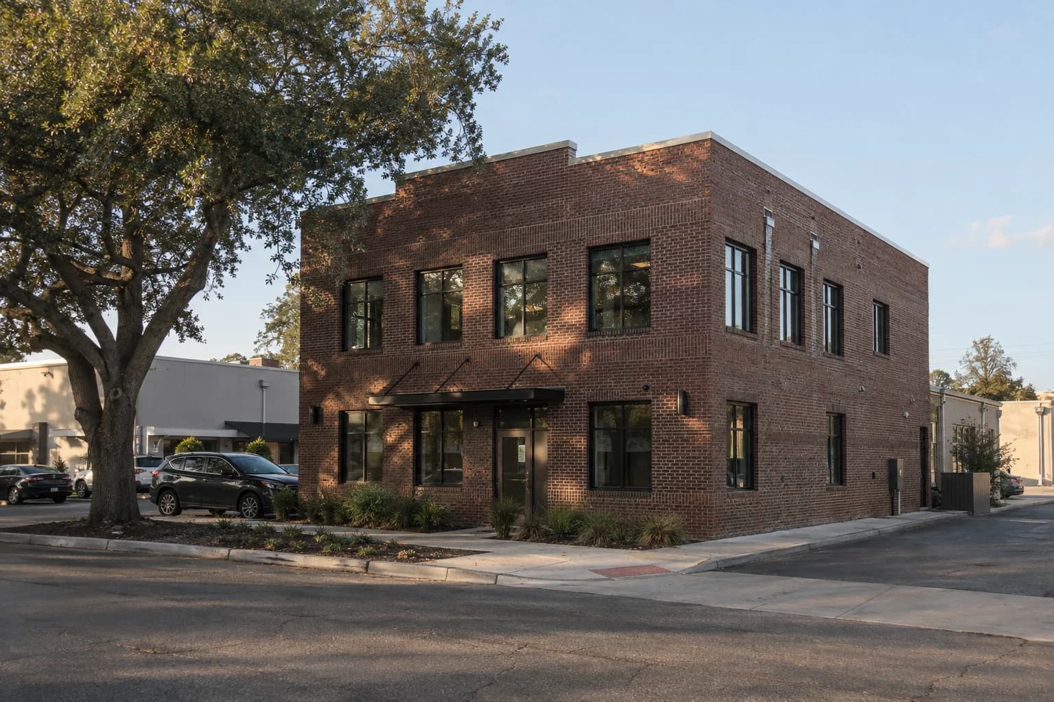 An established brick commercial building in a tree-lined neighborhood